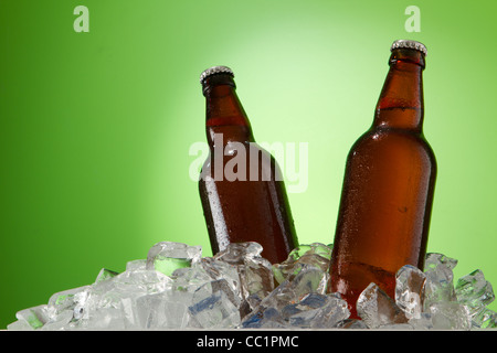 zwei Bierflaschen immer cool in Eiswürfel. Auf einem grünen isoliert. Stockfoto