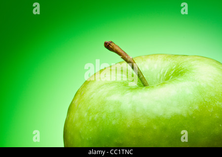 Grüner Apfel. Makro. auf einem grünen Farbverlauf Stockfoto