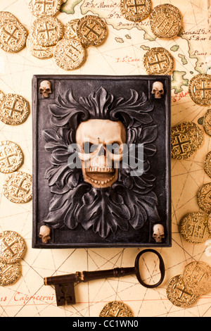 Totenkopf Schatulle mit Skelettschlüssel und Goldmünzen auf alte Karte Stockfoto