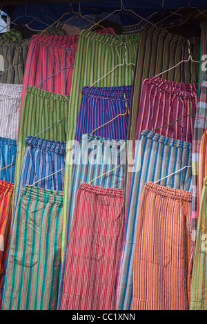 Eine Vielzahl von sehr bunten Stoff Hose hängen in einem Display auf dem Markt in Otavalo, Ecuador. Stockfoto