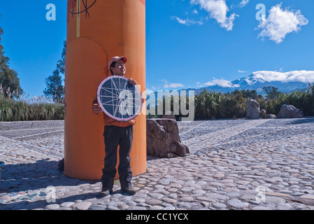 Ein junger Erwachsener lehrt Touristen und anderen Besuchern über den Äquator am Denkmal für den Äquator nördlich von Quito, Ecuador. Stockfoto