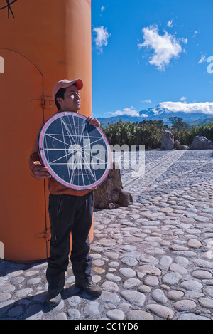 Ein junger Erwachsener lehrt Touristen und anderen Besuchern über den Äquator am Denkmal für den Äquator nördlich von Quito, Ecuador. Stockfoto