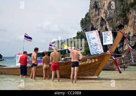 Touristen, die Lebensmittel aus einem Longtail-Boot-Café am Phra Nang Beach (Phra Nang Hut) bestellen. Railay, Krabi, Thailand Stockfoto