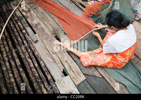 Frau ausbessern Fischernetze an der muslimischen Fischerdorf Dorf von Ko Panyi, Phang-Nga, Thailand Stockfoto