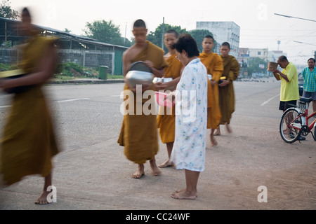 Mönche empfangen Morgen Almosen von Thai-Buddhisten machen Verdienst auf den Straßen von Nakhon Phanom, Provinz Nakhon Phanom, THAILAND Stockfoto