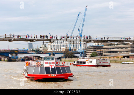 Kreuzfahrt Schiffe, die Touristen auf eine Fahrt auf der Themse und Fußgänger zu Fuß über die Millennium Bridge in London. Stockfoto