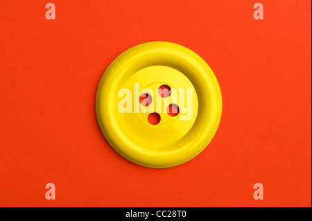 Einen gelben Knopf auf rotem Grund Stockfoto