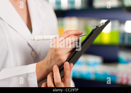 Apothekerin oder Assistent tut Inventar oder Auftragsannahme in Apotheke Stockfoto