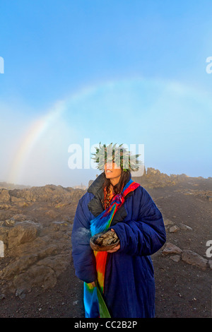 Barbara Bohonu, spirituell/kulturelle Heiler genießen einen Regenbogen kurz nach Sonnenaufgang am Haleakala Krater, Maui, Hawaii, USA. Stockfoto