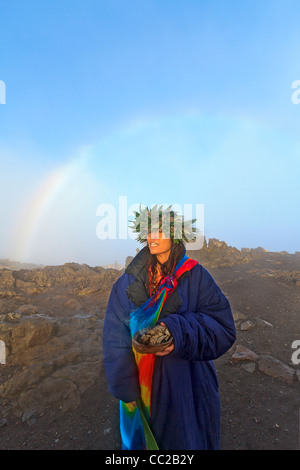 Barbara Bohonu, spirituell/kulturelle Heiler genießen einen Regenbogen kurz nach Sonnenaufgang am Haleakala Krater, Maui, Hawaii, USA. Stockfoto