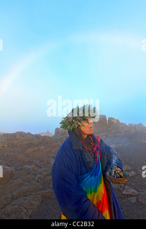 Barbara Bohonu, spirituell/kulturelle Heiler genießen einen Regenbogen kurz nach Sonnenaufgang am Haleakala Krater, Maui, Hawaii, USA. Stockfoto