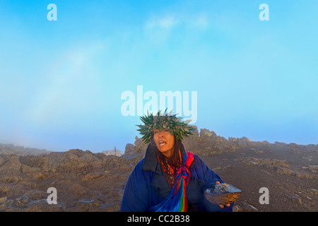 Barbara Bohonu, spirituell/kulturelle Heiler genießen einen Regenbogen kurz nach Sonnenaufgang am Haleakala Krater, Maui, Hawaii, USA. Stockfoto