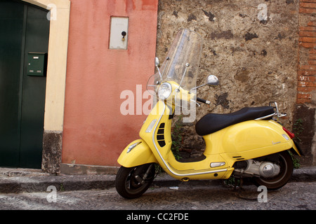 Ein gelber Roller parkten außerhalb einer kleinen italienischen Tür in Sizilien, Italien. Stockfoto