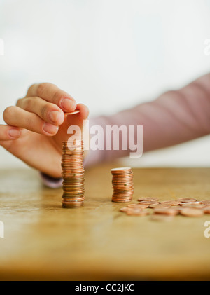 Frau hand stapelnde Münzen, Studio gedreht Stockfoto