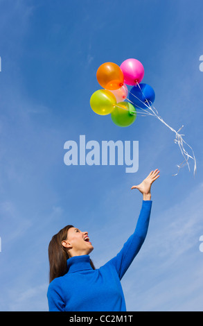 USA, New Jersey, Jersey City, Smiling Frau verlieren Ballons Stockfoto