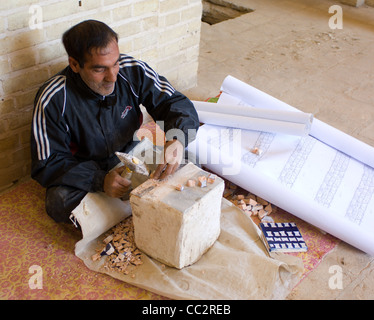 Ein Handwerker arbeitet an die kleine Fliesen durch die Pläne zur Wiederherstellung der Mosaiken in einer Moschee in Yazd, Iran erforderlich machen. Stockfoto