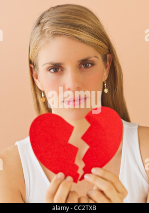 Junge Frau mit Papierherz gebrochen Stockfoto