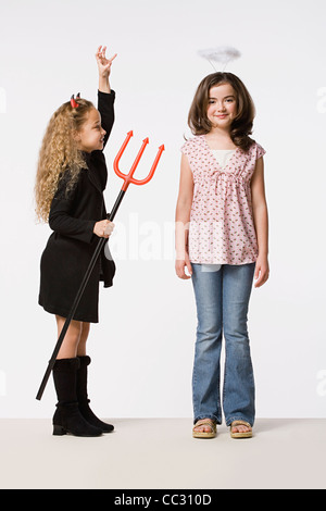 Zwei Mädchen (8-9) verkleidet als Engel und Teufel, Studio gedreht Stockfoto