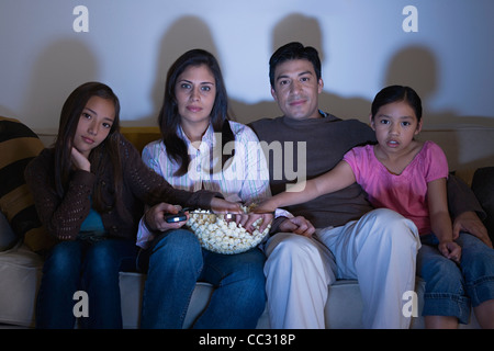 Familie mit zwei Töchtern (8-9, 10-11), Los Angeles, California, USA Fernsehen auf Sofa Stockfoto