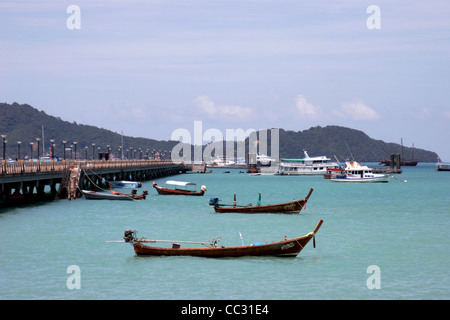 Eine Gruppe von Fischen und Ausflugsboote sind gefesselt in der Nähe von einem Pier in Chalong Bay, Insel Phuket, Thailand. Stockfoto