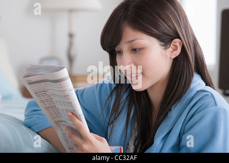 USA, California, Los Angeles, Frau lesen Zeitung zu Hause Stockfoto