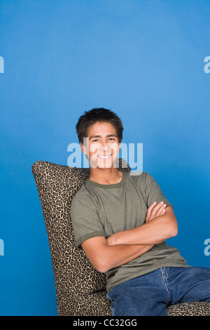 Porträt von Teenager (16-17) sitzen im Stuhl Stockfoto