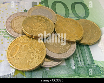 Haufen von Münzen auf 100 Euro-banknote Stockfoto