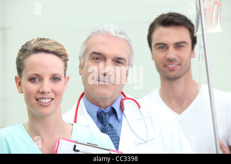 Patient am Tropf mit seinem Ärzteteam Stockfoto