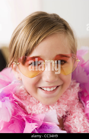 Porträt von lächelndes Mädchen (10-11) tragen Federboa und eine Sonnenbrille, Los Angeles, California, USA Stockfoto