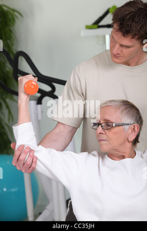 Ältere Frau heben der Hantel mit Fitness-coach Stockfoto