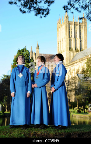 Drei junge Chorsänger aus der Wells Cathedral Choir in Somerset Proben im Freien für Weihnachten carol Dienstleistungen von "Der Brunnen" Stockfoto