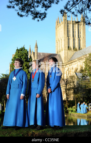 Drei junge Chorsänger aus der Wells Cathedral Choir in Somerset Proben im Freien für Weihnachten carol Dienstleistungen von "Der Brunnen" Stockfoto