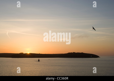 Die Sonne geht über St Anthony Head, Roseland Halbinsel Cornwall von Pendennis Punkt gesehen. Stockfoto