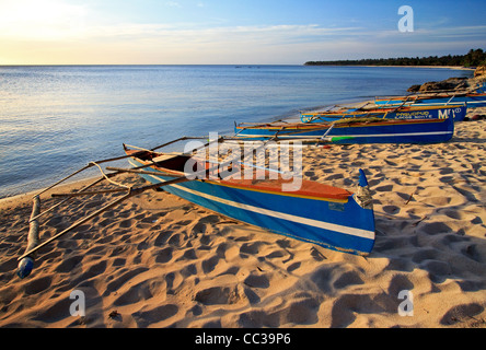 Gestrandeter traditionellen philippinischen Boote bekannt als Banka, wie gesehen, wenn die Sonne auf Saud Strand in Pagudpud, Luzon, Philippinen untergeht Stockfoto
