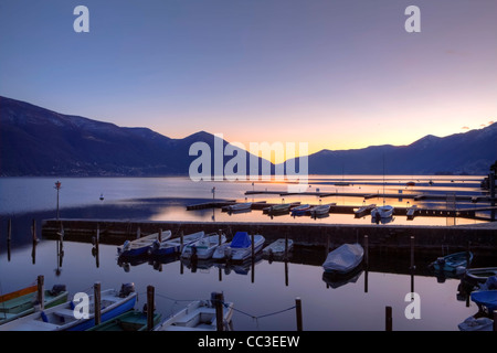 Bootsstege in Ascona, Tessin, Schweiz bei Sonnenuntergang während der blauen Stunde. Stockfoto