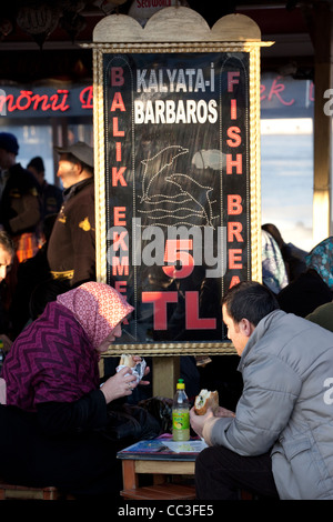 Paar Essen Fischbrötchen in Eminönü in der Nähe von Galata-Brücke, Istanbul, Türkei Stockfoto