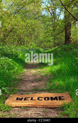 Konzept-Foto von Welcome Fußabtreter auf einem Wald Wanderweg im Frühling in Hochformat. Stockfoto