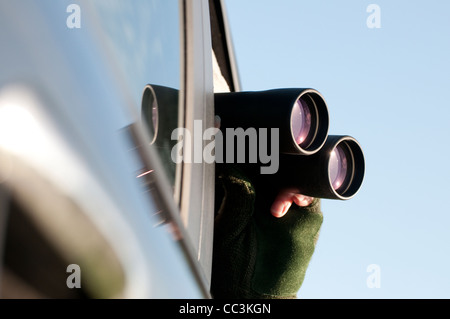 Person Blick durch ein Fernglas sitzen im Auto Stockfoto