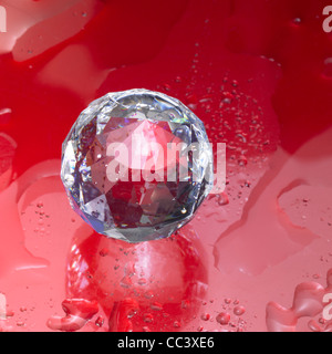 Studio-Fotografie ein Diamant Kugel aus Glas in nassen rot glänzend zurück Stockfoto