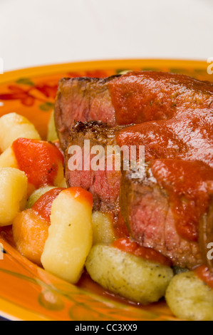 Steak mit Tomatensauce auf Kartoffeln, Spinat und Tomaten-Gnocchi Stockfoto