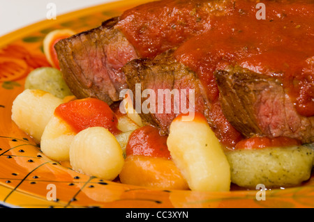 Steak mit Tomatensauce auf Kartoffeln, Spinat und Tomaten-Gnocchi Stockfoto