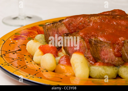 Steak mit Tomatensauce auf Kartoffeln, Spinat und Tomaten-Gnocchi Stockfoto