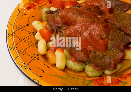 Steak mit Tomatensauce auf Kartoffeln, Spinat und Tomaten-Gnocchi Stockfoto