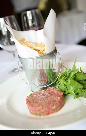 Steak Tartar mit Pommes Frites und Rucola Stockfoto