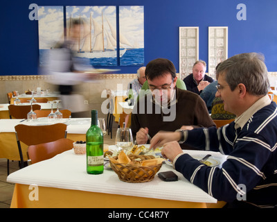 Kunden, die mit Bewegung verwischt Kellner vorbei an belebten Restaurant Essen Stockfoto