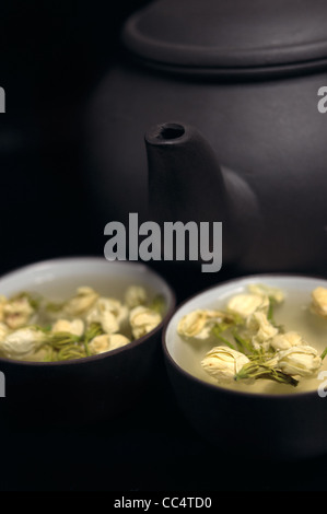 Chinesischer Jasmintee Topf und Tassen über schwarz Stockfoto