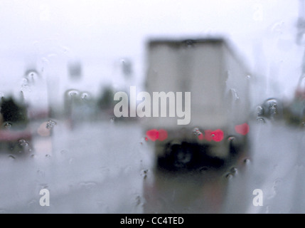 32,243.24200 Verschwommene Ansicht des hinteren Semi Truck auf rutschigem Untergrund nassen Autobahn Straße in Regen Regen, schlechte Sichtverhältnisse nassen Windschutzscheibe; Verkehr, Gefahr. Stockfoto