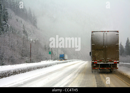 40,526.02104 Zwei 18 Wheelers im Schnee Sturm auf glatten Schnee 4-spurige Landstraße abgedeckt, Ketten erforderlich, schneit Gefährliche gefährliches Fahren Stockfoto