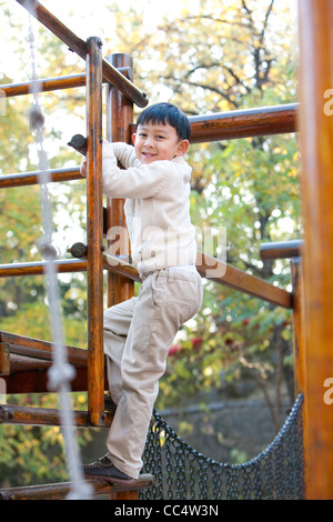 Junge Aufstieg auf einem Spielplatz Stockfoto