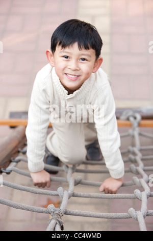 Junge Klettern Spielplatz Strickleiter Stockfoto